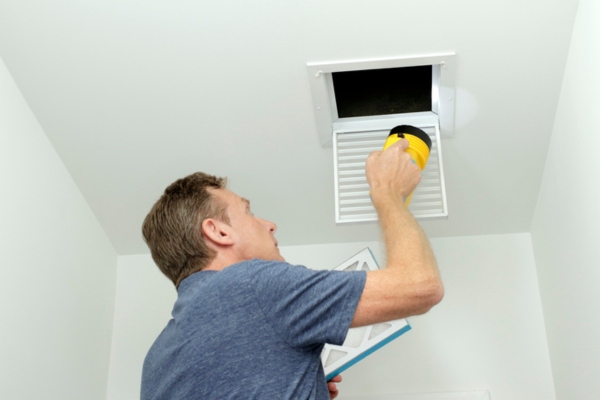homeowner inspecting air vent and ducts
