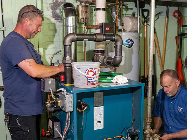 Modern Comfort HVAC technicians repairing a boiler