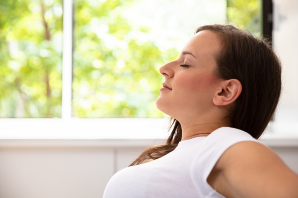 woman breathing easy at home depicting mold-free AC system