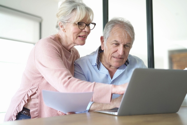 senior couple searching the internet for certified HVAC professionals for an Air Conditioner Replacement Company