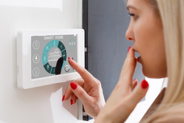 woman looking confused while controlling smart air conditioner thermostat setting