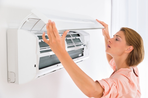 woman examining home's ductless air conditioner