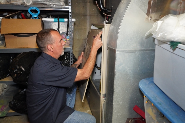 Modern comfort HVAC technician servicing a furnace