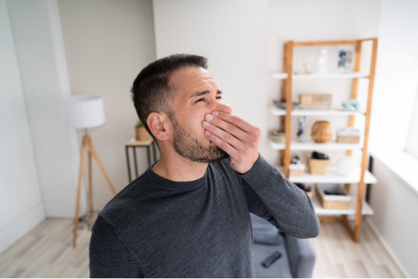 man covering his nose depicting unusual furnace odor