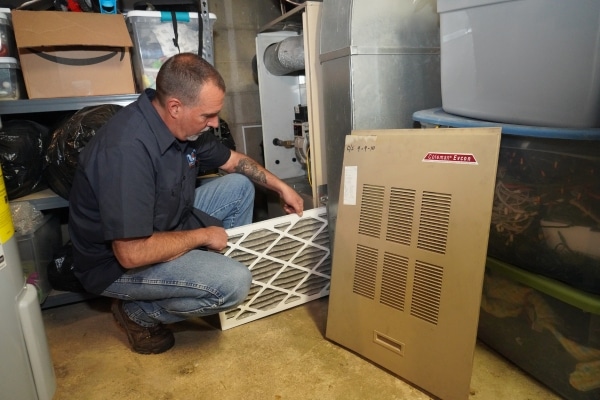 Modern Comfort HVAC technician replacing furnace filter