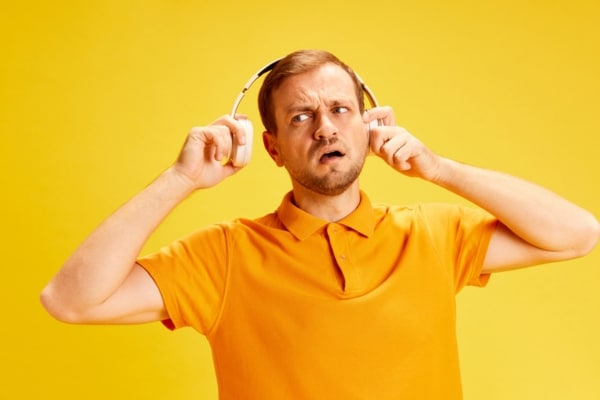 image of a confused man wondering if humming sound comes from earphones or furnace