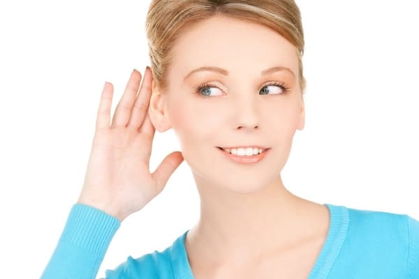 woman holding ear up depicting furnace noise meaning