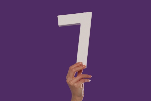 Female hand holding up the number 7 from the bottom depicting furnace preparation tips