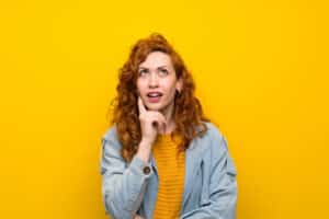 woman thinking about what to look for when buying a new furnace