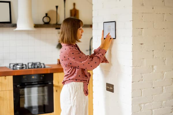 woman using smart thermostat after furnace replacement