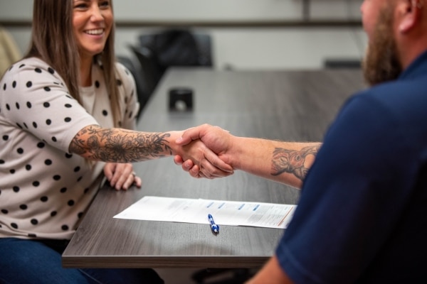 Modern Comfort HVAC technician shaking hands with client depicting customer service